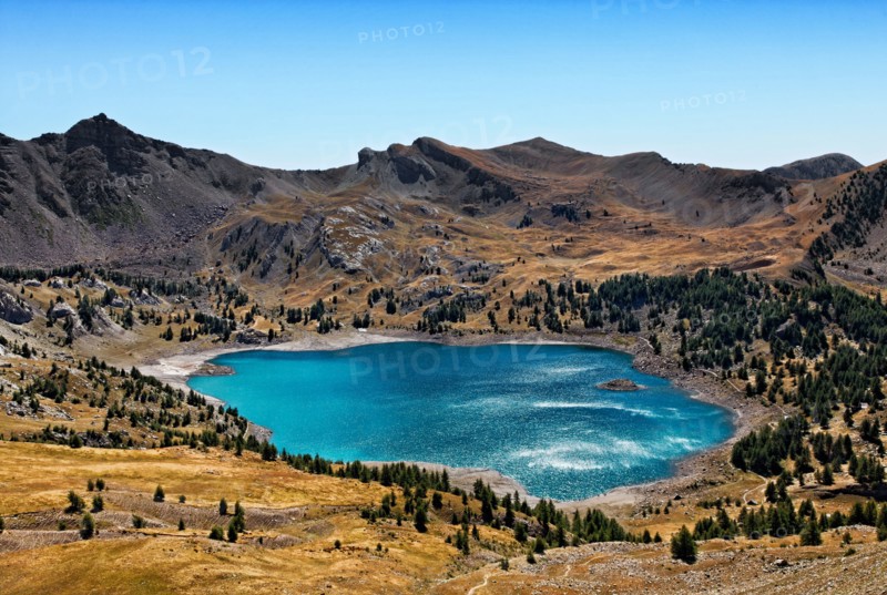 Image of Lac D'Allos (2228 m) during a windy day with sunlight reflections on the rippled water surface.