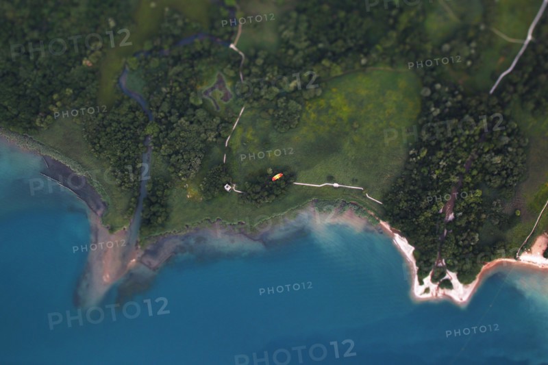 Aerial view of a paraglider flying next to Lake Annecy.