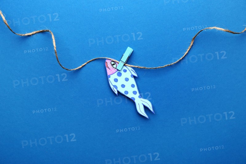 Paper fish on color background. April Fool's Day prank