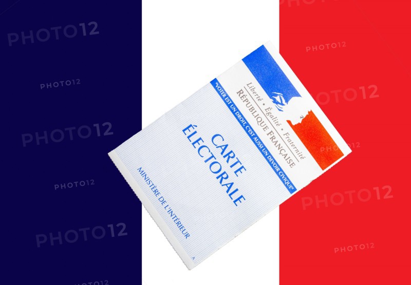 french voting card or carte electorale on top of French flag .