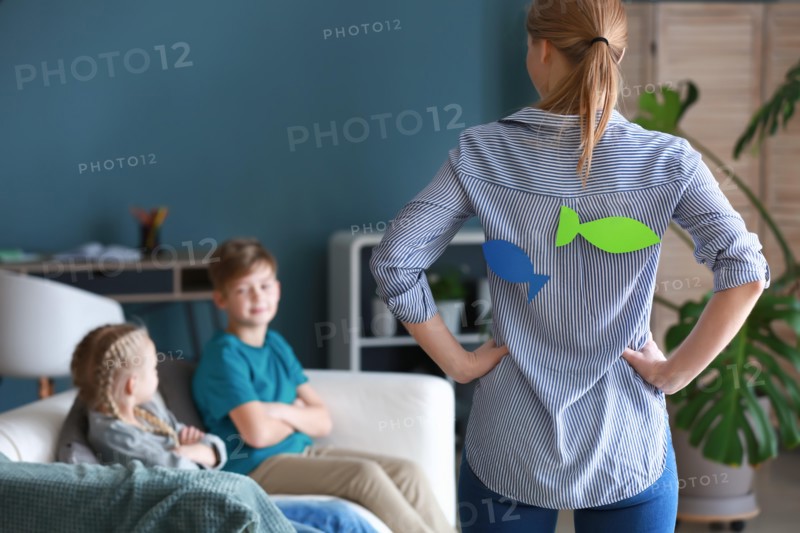 Mother with paper fish on her back scolding children. April fools' day prank