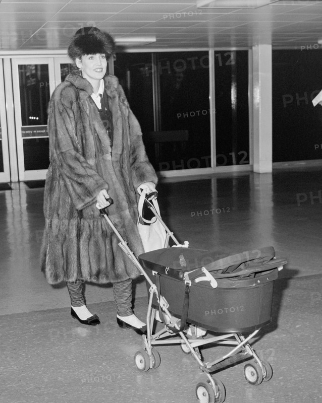 Texan model and wife of Rolling Stone Mick Jagger arriving at London's Heathrow Airport with daughter Elizabeth Scarlett in 1985.