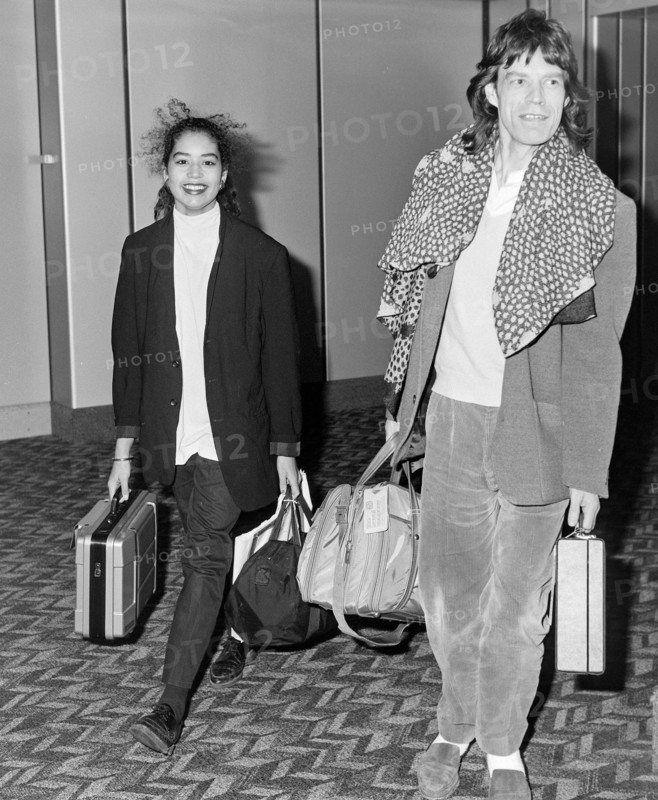 Rolling Stone Mick Jagger with his daughter Karis arriving at London's Heathrow Airport in December 1986.