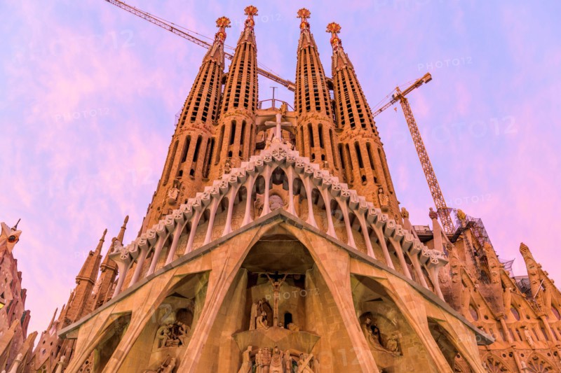 Sagrada Familia - A close-up wide-angle view of west Passion facade of Basílica de la Sagrada Família, against colorful Autumn sunset sky. Barcelona.