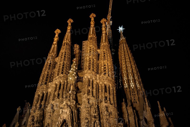Façana del Naixement (Facade of the Birth) and the star of the Mary tower illuminated at night in the Sagrada Familia (Barcelona, Catalonia, Spain)