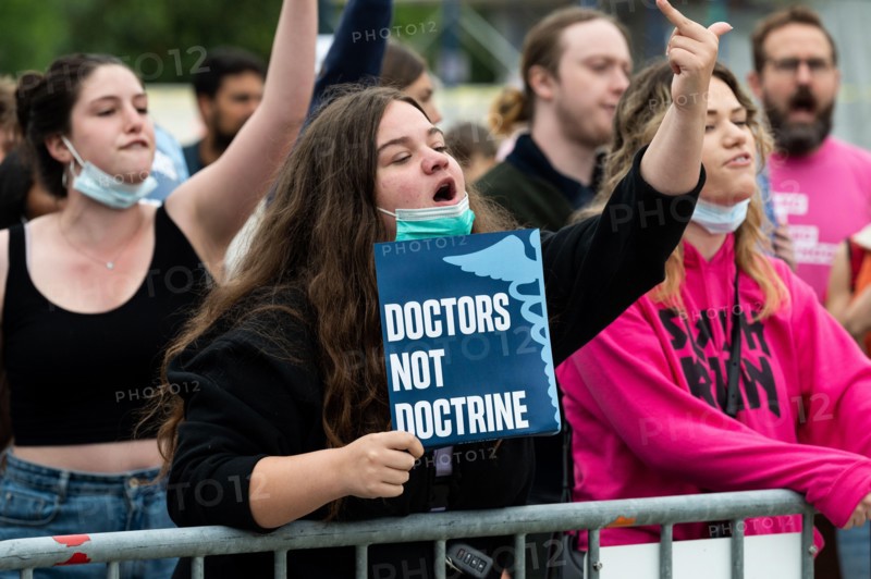 A protester shouts slogans and holds a placard reading "Doctors not doctrine" during an abortion related demonstration in front of the Supreme Court.