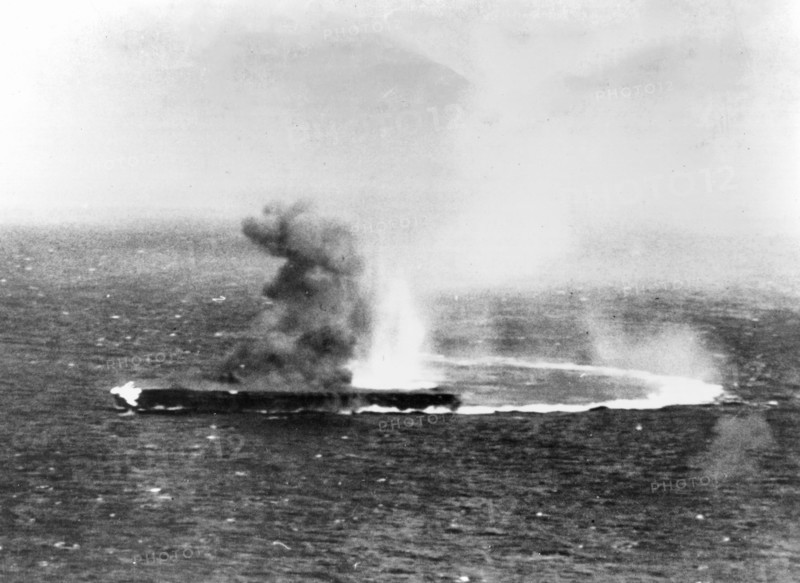 Japanese aircraft carrier Shokaku under dive bombing attacks by USS Yorktown (CV-5) planes, during the morning of 8 May 1942. Flames are visible from a bomb hit on her forecastle.