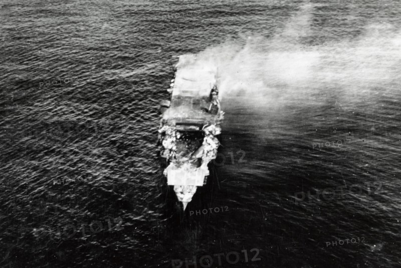The burning Japanese aircraft carrier Hiryu, photographed by a Yokosuka B4Y aircraft from the carrier Hosho shortly after sunrise on 5 June 1942. Hiryu sank a few hours later. Note the collapsed flight deck over the forward hangar.  Battle of Midway