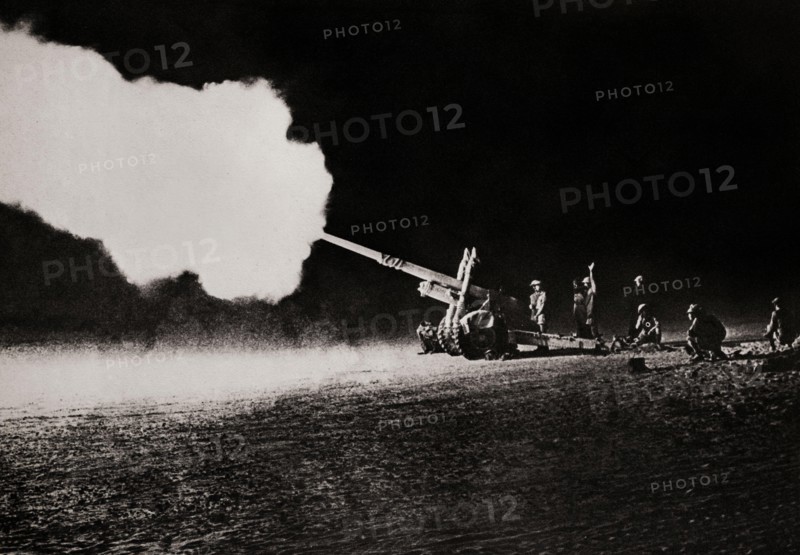 The 4.5 inch field gun bombarding enemy (German) tanks during the Second Battle of El Alamein (23 October – 11 November 1942) which prevented the Axis from advancing further into Egypt. It was a good weapon that could fire a 25 kg  shell up to 11.6 miles matching German 10.5 cm and 150 mm howitzers in range and firepower.