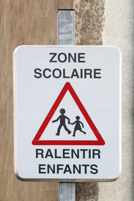 School zone slow down children road sign in French language