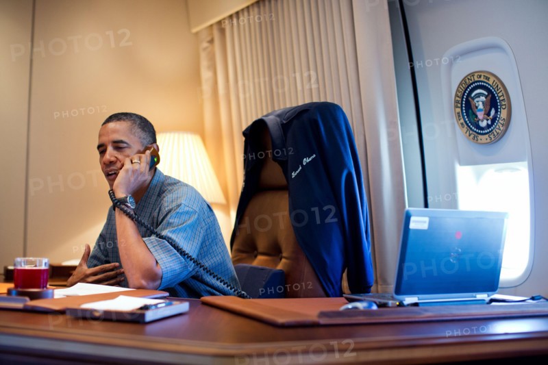 President Barack Obama talks on the phone with NASA's Curiosity Mars rover team aboard Air Force One during a flight to Ouffutt Air Force Base in Nebraska, Aug. 13, 2012.