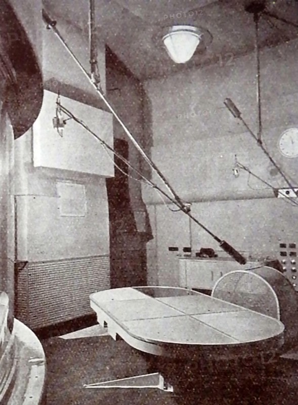 A very early printed photograph of a BBC announcer reading the news.  The BBC began daily radio services in London  in the 1920s on the radio station 2LO. Under the general management of 33 year old John Charles Walsham Reith  the BBC  began to expand its programmes on 14 December 1922. The  first chief engineer was Peter Eckersley. 1927 saw the establishment of British Broadcasting Corporation  by Royal Charter with Reith as its first Director-General.  John Logie Baird  began experimenting  with television broadcasts on BBC frequencies in November 1929..