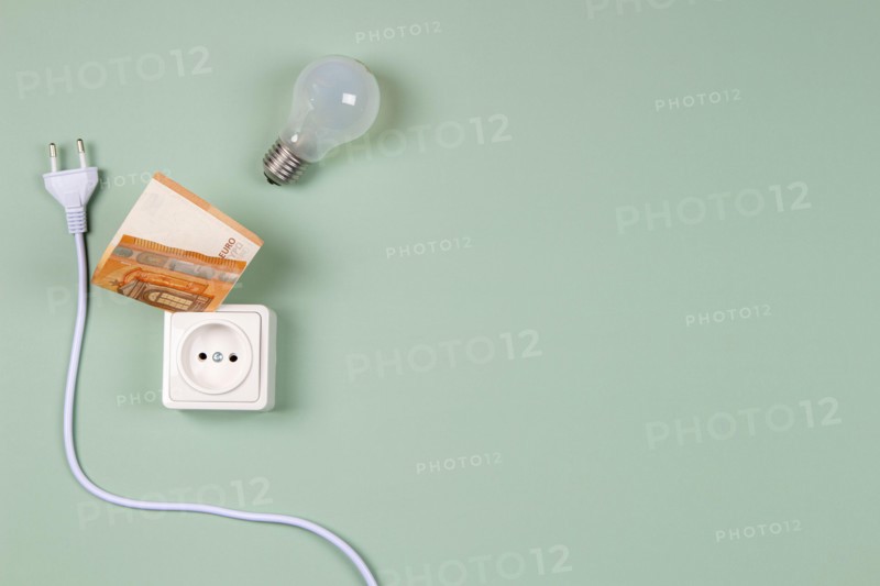 Electric power plug, light bulb and electric socket with Euro banknotes on light green background. Electricity cost and expensive energy concept