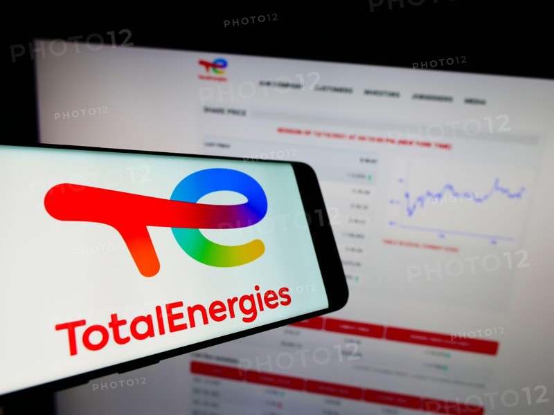 Smartphone with logo of French oil and gas company TotalEnergies SE on screen in front of business website. Focus on center-right of phone display.