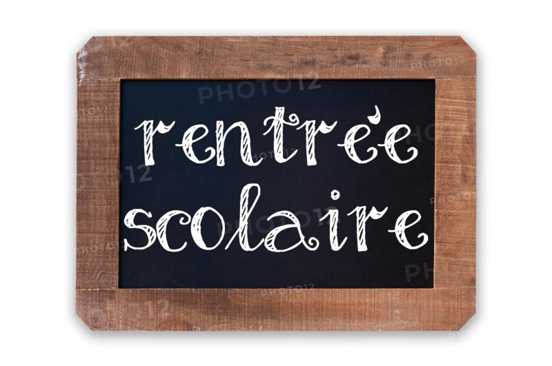 Rentree scolaire (meaning Back to school) written on a vintage blackboard with wooden frame isolated on white background