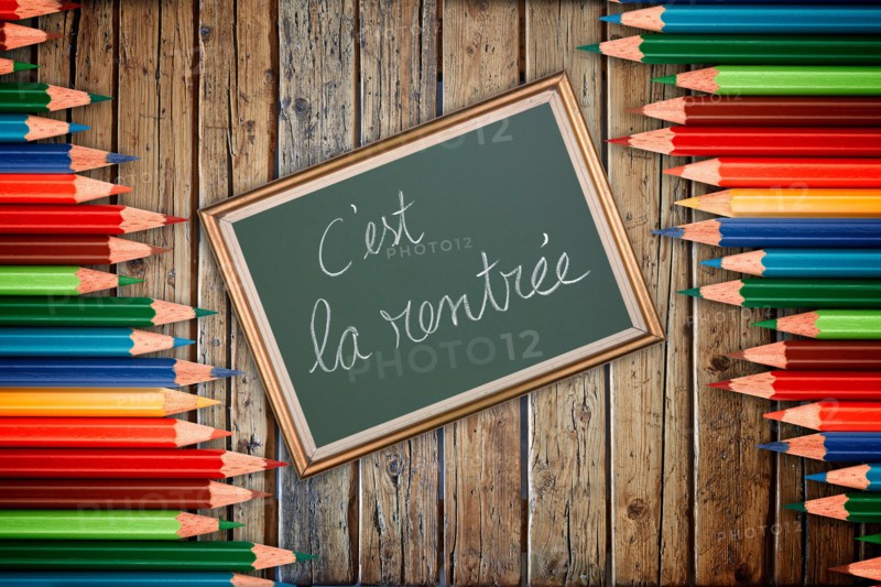 Wooden textured table from above and back to school concept in french