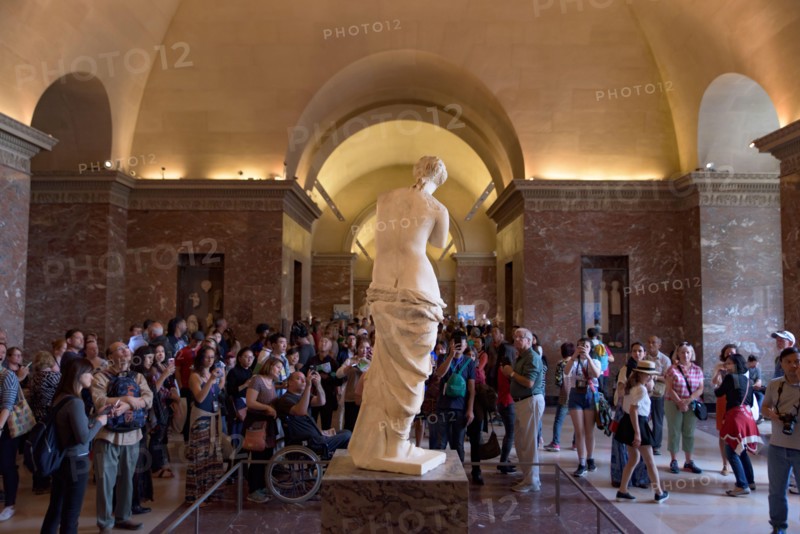 People around Venus de Milo (Aphrodite of Milos), one of the most famous ancient Greek sculpture, on display at the Louvre Museum in Paris, France