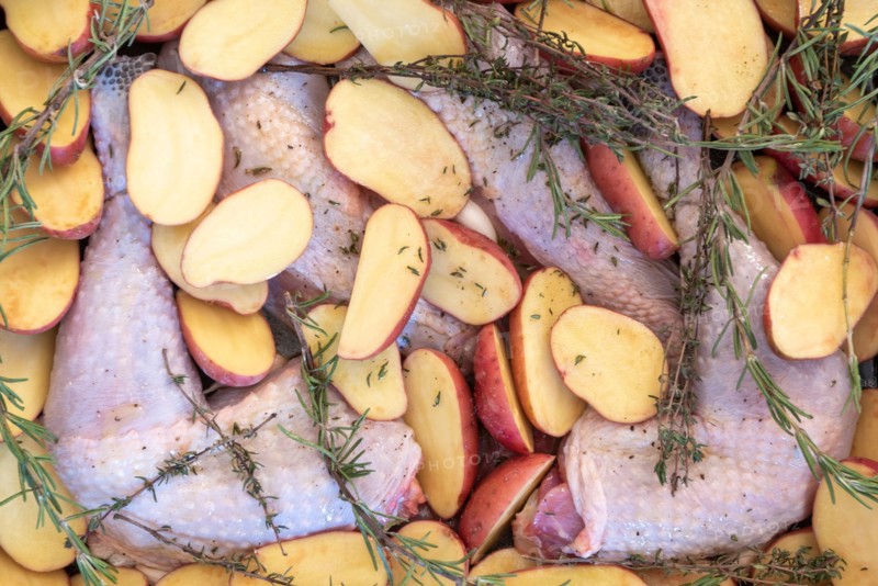 Food, preparation, black chicken, halved potatoes, rosemary, Christmas dinner.
