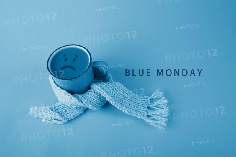 Blue cup with scarfcoffee on blue background. Blue monday concept