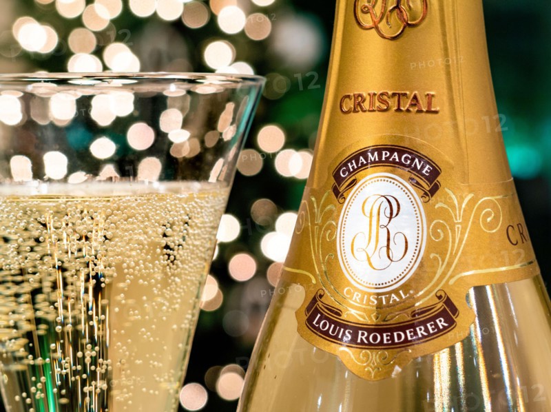 CRISTAL CHAMPAGNE Bottle and freshly poured glass of Louis Roederer Cristal luxury champagne with sparkling party celebration  lights in background