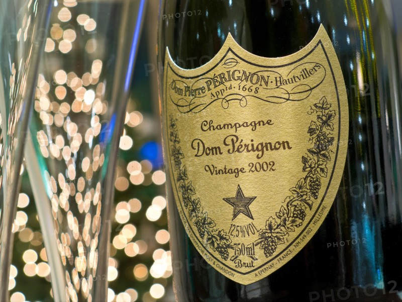 Dom Perignon vintage 2002 luxury champagne and glasses with sparkling lights in background
