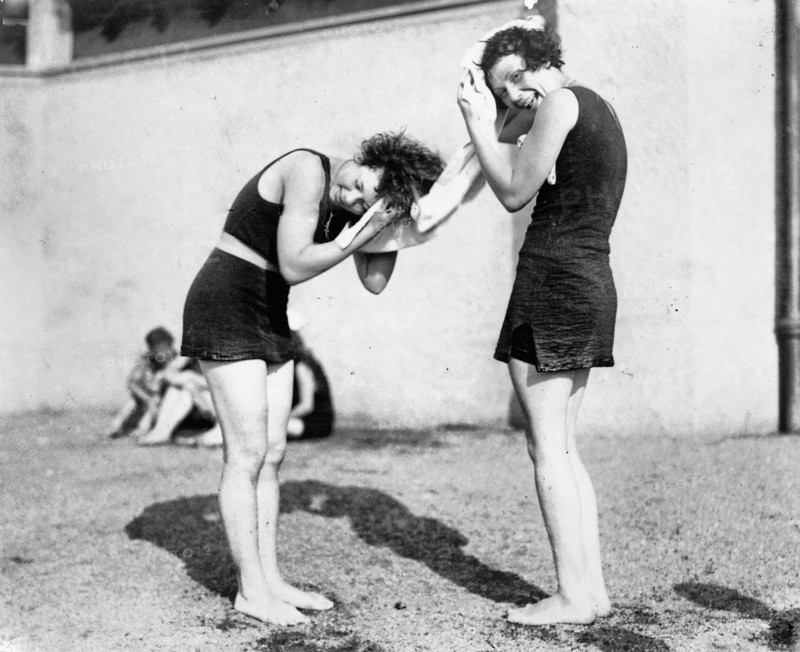 Two women in bathing costumes drying their hair, circa 1925