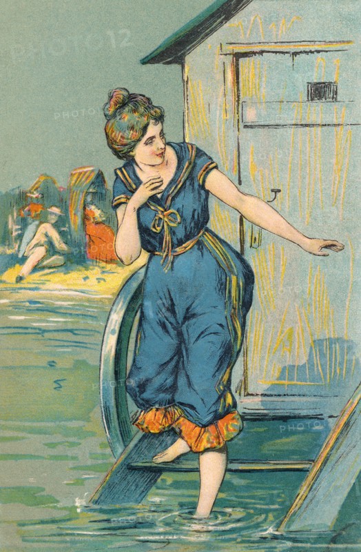 Postcard - vintage illustration of an Edwardian lady in bathing costume stepping into the sea from a bathing hut.