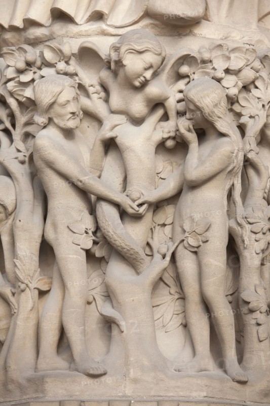 Adam and Eve. Detail of the main facade of the Notre-Dame Cathedral (Notre-Dame de Paris) in Paris, France. The damaged Gothic portal was restored by French architects Eugene Viollet-le-Duc and Jean-Baptiste Lassus in the 1840s.
