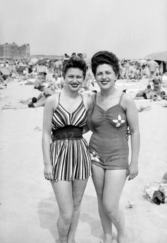 Sisters pose together on the beach in fashionable swimwear, ca. 1946.