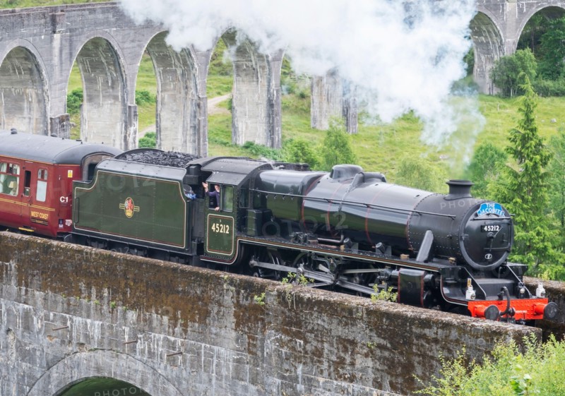 Glenfinnan,Inverness-shire,Scottish Highlands-July 21 2022:The train driver waves and lets off steam to onlookers,as the iconic train,shown in Harry P