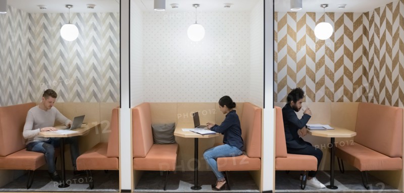 Workflow in modern coworking space of three diverse businesspeople