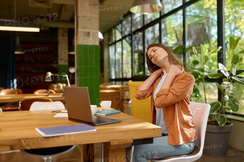 Tired young business woman working at coworking space