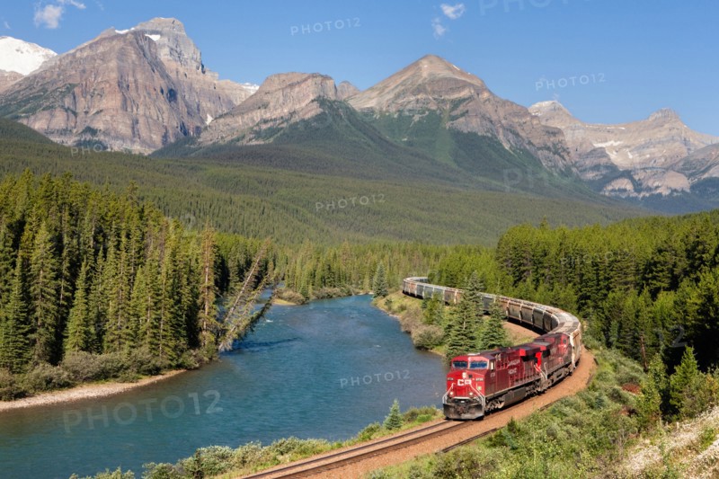 Train and railway with mountain scenery: A Canadian Pacific diesel locomotive transporting freight in Banff National Park.
