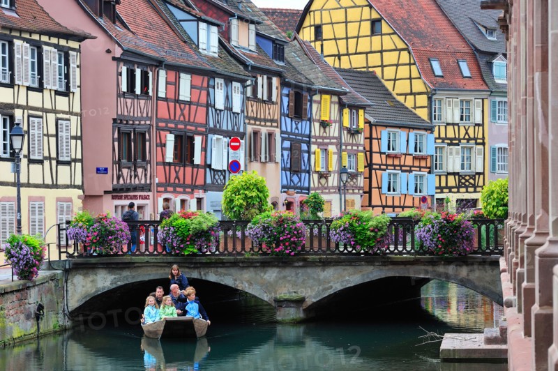 Tourists in boat at sightseeing trip along the colorful timber framed houses at Petite Venise / Little Venice, Colmar, France