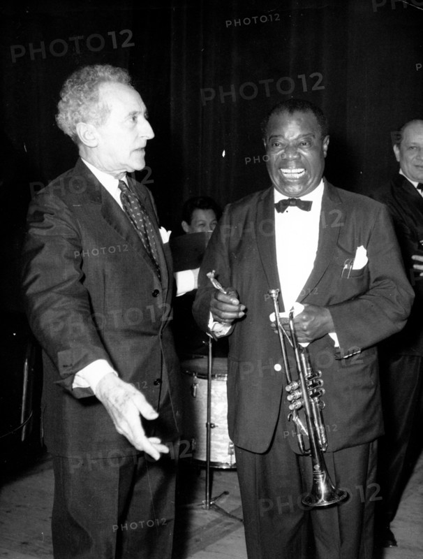 Jean Cocteau talking with a musician