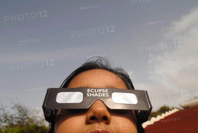 A young girl watches the partial solar eclipse by wearing a protected filter on 1st August 2008 in Bombay Mumbai