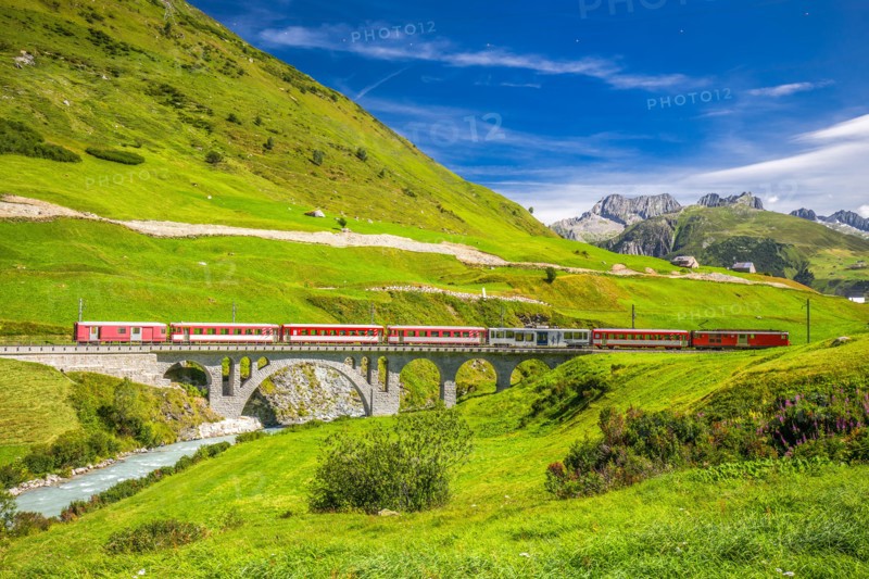 The Matterhorn - Gotthard - Bahn train on the viaduct bridge near Andermatt. It is a narrow gauge railway in Switzerland, Europe.