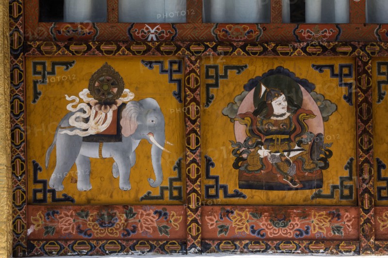 Buddhist religious paintings, including a Dharma Wheel on the back of an elephant on the Buddhist temple in Punakha, Bhutan