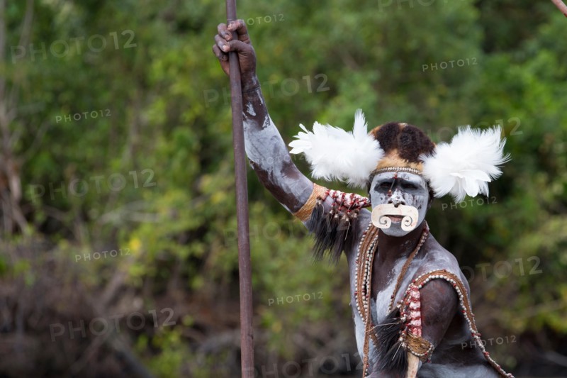 Local in traditional attire canoeing, Papua, Syuru village, Asmat region.