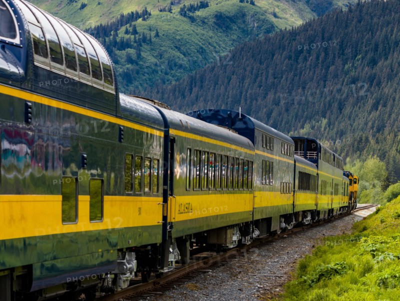 Snow capped mountains in background of Alaska Railroad’s Coastal Classic train from Anchorage to Seward Alaska