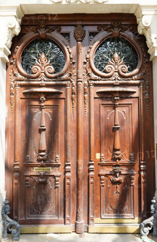 Old ornate door in Paris, France - typical old apartment building.