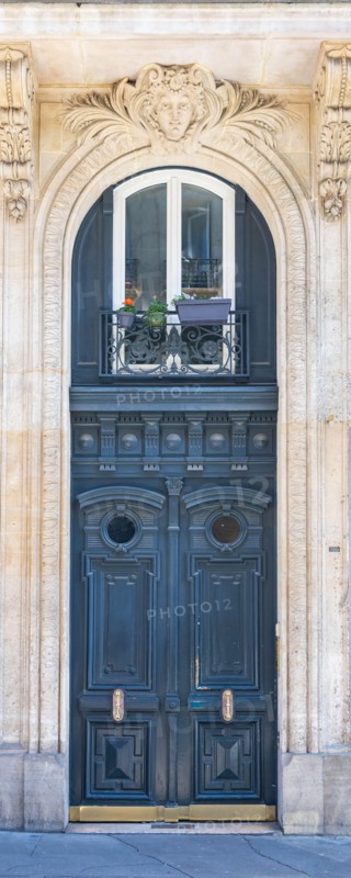 Paris, an ancient wooden door, typical building in the 11e arrondissement