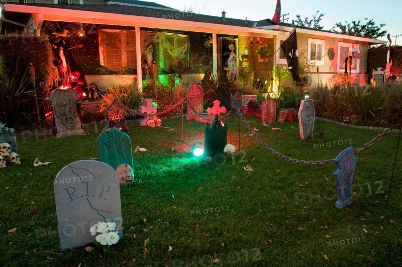 Front lawn decorated as a spooky cemetery for Halloween with tombstones and skeletons