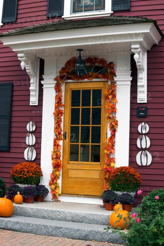 Front door of a traditional clapboard New England house, decorated for Halloween