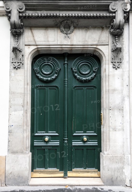 Dark green wooden door in old building facade. Paris, France