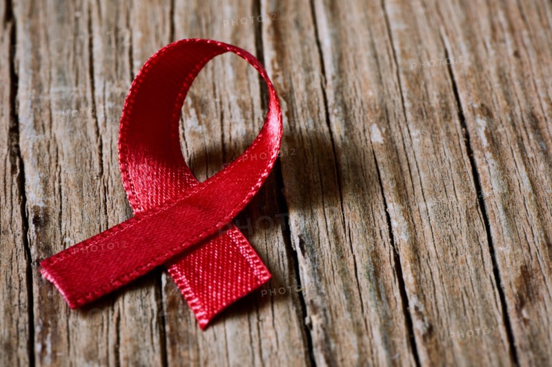 a red ribbon for the fight against AIDS on a rustic wooden surface