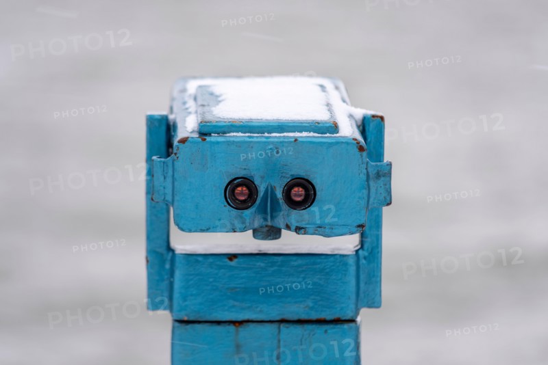 Old coin operated telescope on the seafront in Southend on Sea, Essex, UK, with snow from Storm Darcy. Looks like a face