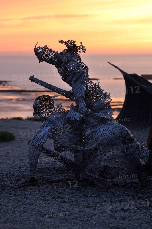 Life size sculptural figure in the D-Day 75 Garden in Arromanches-les-Bains, France at Sunset. The installation was first created by John Everiss for