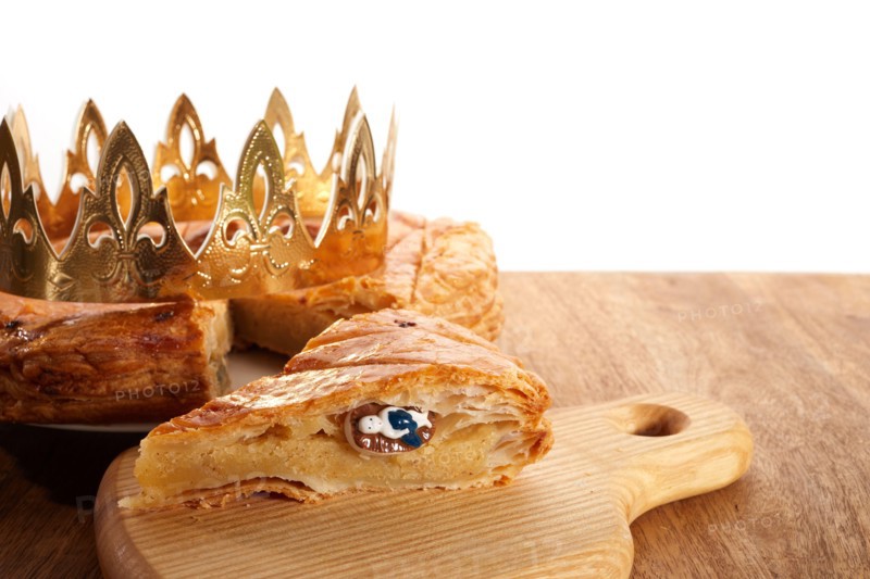 King cake or galette des rois in French. Epiphany pie with golden paper crown and little ceramic figurine