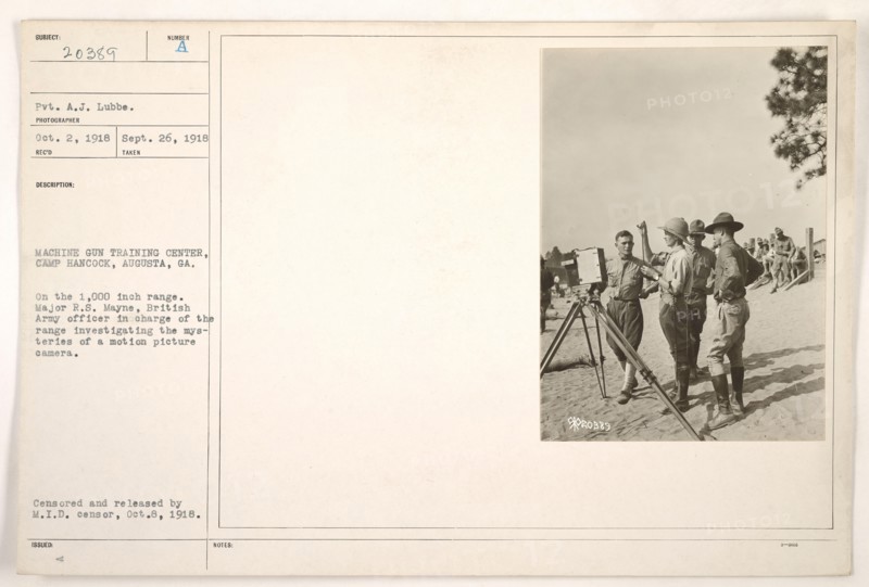 Major R.S. Mayne, a British Army officer, is seen investigating a motion picture camera at the Machine Gun Training Center in Camp Hancock, Augusta, Georgia. This image documents the military's interest in utilizing motion picture technology during World War I for training purposes. Photograph taken on September 26, 1918.